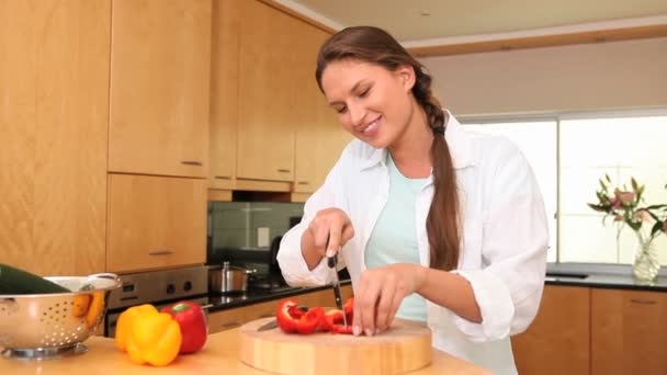 Jonge vrouw snijden paprika 's — Stockvideo