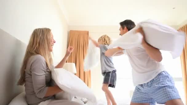 Молодая семья борется на подушках — стоковое видео