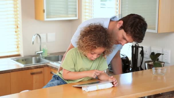 Boy using a ebook with his father — Stock Video