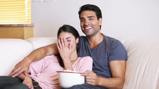 Couple riant regardant la télévision — Video
