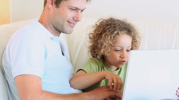 Vater und Sohn sehen sich Video auf Laptop an — Stockvideo