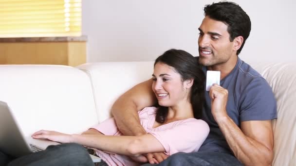 Couple lying on a couch while making shopping online — Stock Video