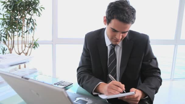 Empresario escribiendo en una hoja — Vídeos de Stock