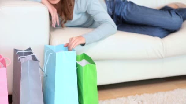 A nő mosolyogva, miközben keresi a bevásárló szatyrok — Stock videók