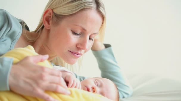 Mujer sosteniendo a un bebé en una manta amarilla — Vídeos de Stock