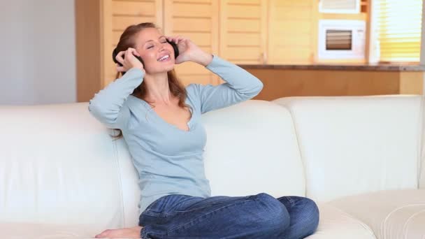 Mujer joven escuchando música con auriculares — Vídeos de Stock