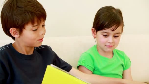 Hermano y hermana leyendo un libro — Vídeo de stock