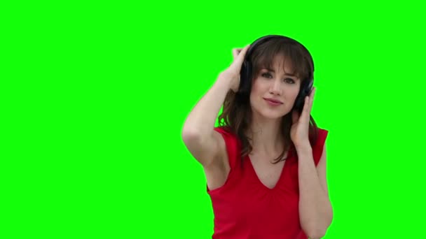 Woman dancing while holding headphones against her head — Stock Video