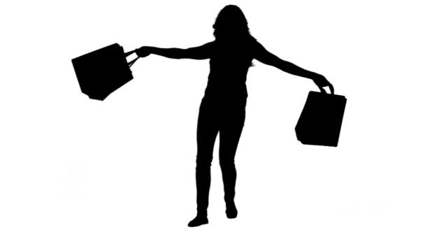 Silhouette of an energetic woman holding shopping bags — Stock Video