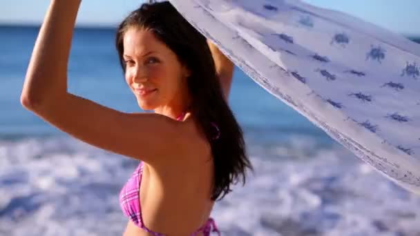 Smiling brunette holding her sarong — Stock Video