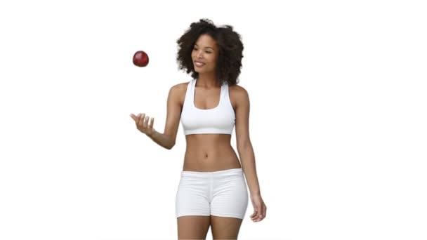 Mujer en ropa de entrenamiento lanza una manzana hacia arriba — Vídeos de Stock