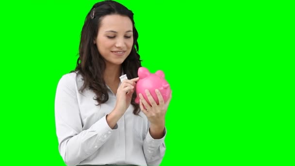 Vrouw geld steken in haar piggy-bank — Stockvideo