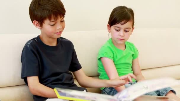 Bambini seduti mentre leggono un libro — Video Stock