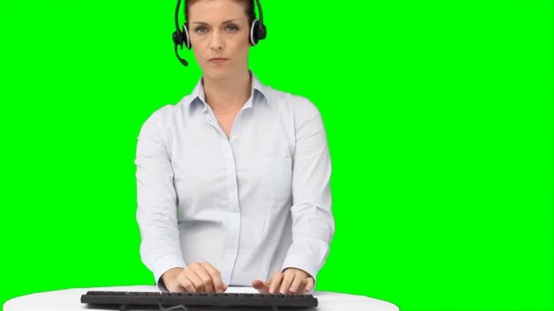 Bir kadın onun klavyede yazarak bir kulaklık ile — Stok video
