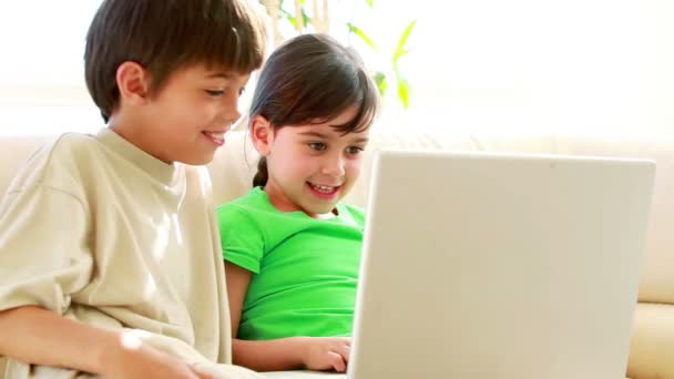 Hermanos usando una laptop juntos — Vídeos de Stock