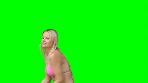 Een vrouw in een bikini gooit een frisbee buiten het scherm meerdere keren — Stockvideo