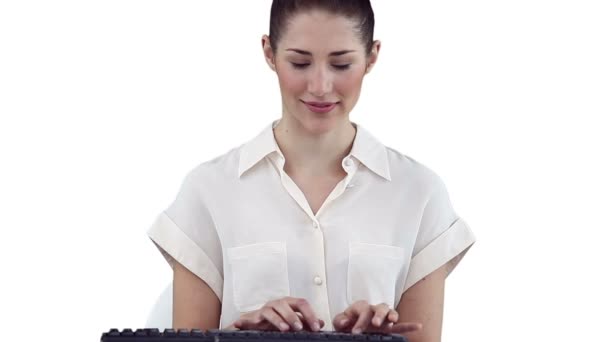 Mujer sonriendo mientras escribe en un teclado — Vídeo de stock