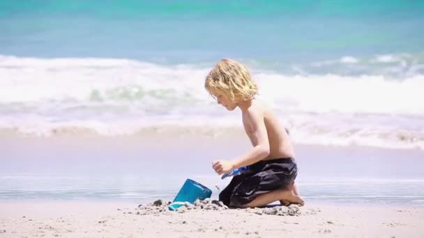 Niño rubio jugando con una pala — Vídeo de stock