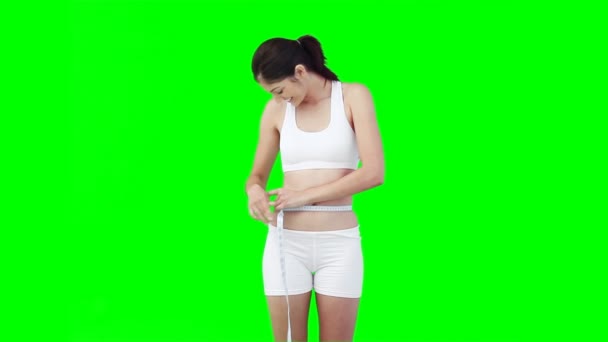 A woman uses a measuring tape to check her waist line — Stock Video