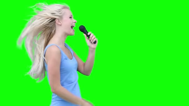Блондинка поет в микрофон — стоковое видео