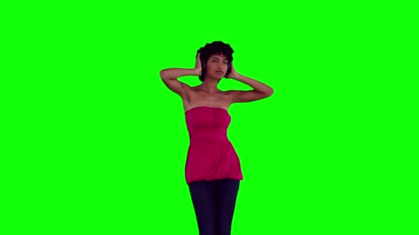 Mujer sosteniendo auriculares contra su cabeza mientras baila — Vídeo de stock