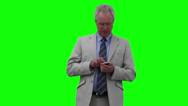 Geschäftsmann drückt Tasten auf seinem Handy, während er sich umschaut — Stockvideo