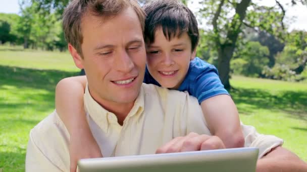 Vader en zoon kijken naar een ebook — Stockvideo