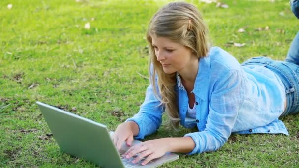 Vrouw liggen tijdens het gebruik van een laptop — Stockvideo