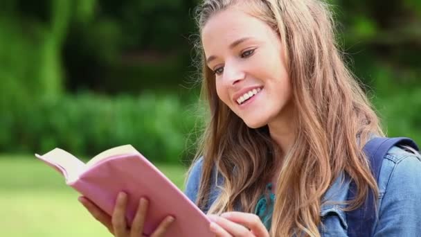 Mulher feliz lendo um livro fascinante — Vídeo de Stock