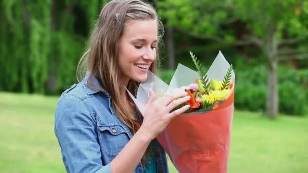 Молода жінка тримає купу квітів — стокове відео