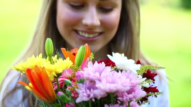 Mutlu genç bir kadın tutarak çiçekler — Stok video