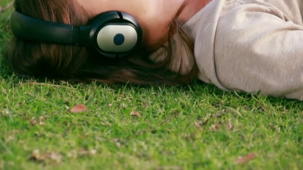 Frau hört Musik in einem Park — Stockvideo