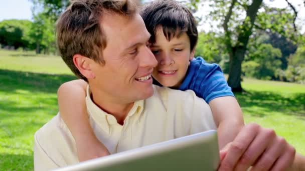 Щасливий батько і син використовують планшетний комп'ютер — стокове відео