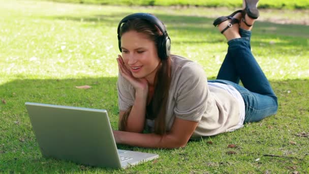 Mujer escuchando música con un portátil delante de ella — Vídeos de Stock