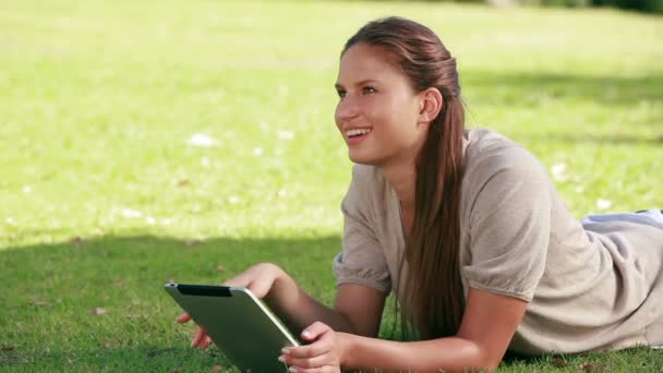 Mulher usando um ebook em um parque — Vídeo de Stock
