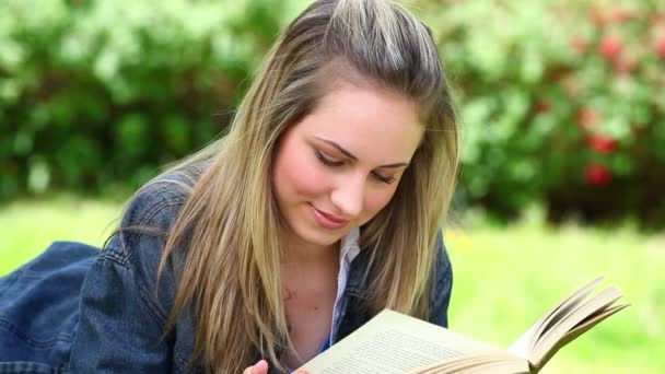 Glückliche blonde Frau liest ein Buch — Stockvideo