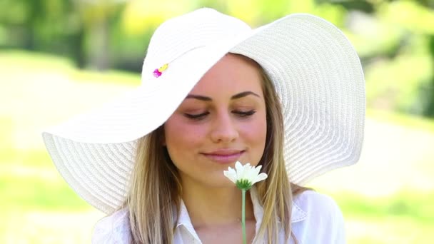 Mujer sonriente sosteniendo una flor blanca — Vídeo de stock