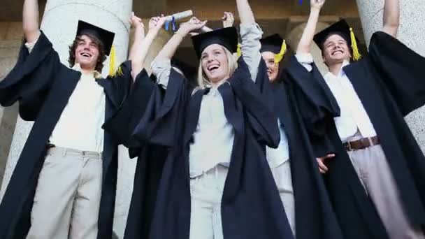 Estudiantes graduados felices levantando sus brazos — Vídeo de stock