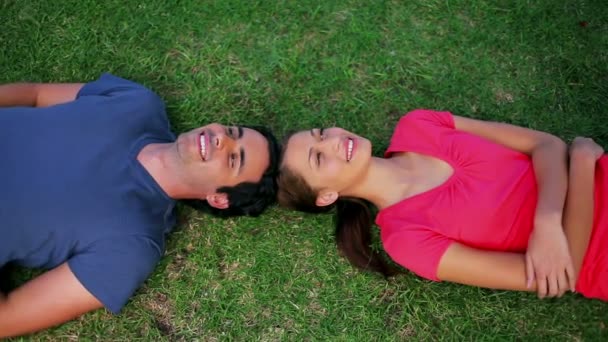 Smiling couple lying on the grass — Stock Video