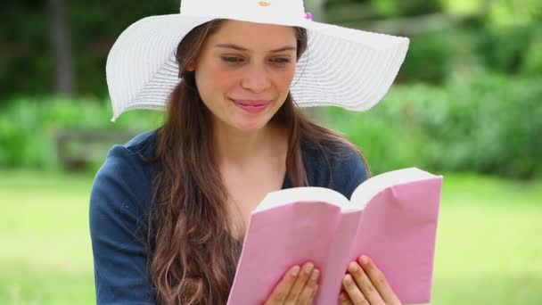 Glückliche Brünette liest ein Buch — Stockvideo