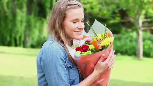 Giovane donna felice che tiene un mazzo di fiori — Video Stock