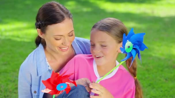 Moeder en dochter houden pinwheels — Stockvideo