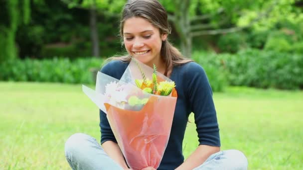 Alegre joven mujer oliendo flores — Vídeo de stock