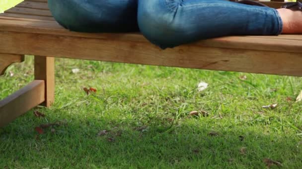 Young woman sitting on a bench — Stock Video