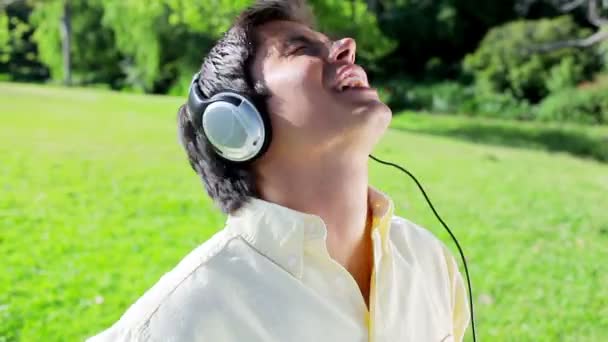 Счастливый человек слушает музыку во время пения — стоковое видео