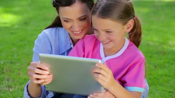 微笑着与她的女儿使用 tablet pc 的女人 — 图库视频影像