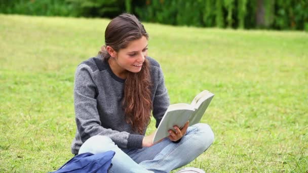 Glückliche junge Frau beim Lesen eines faszinierenden Romans — Stockvideo