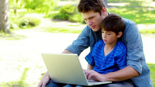 Zoon en zijn vader met behulp van een laptop — Stockvideo