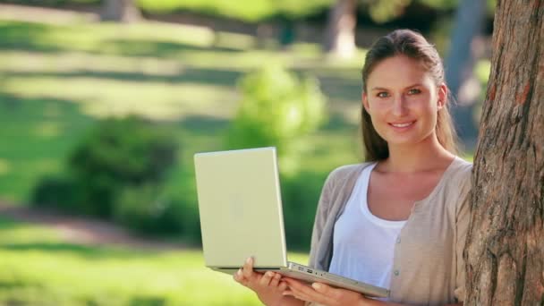 Uma mulher está segurando um laptop — Vídeo de Stock