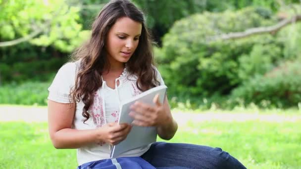 Mujer sonriente buscando un cuaderno — Vídeos de Stock